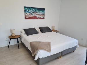 Un dormitorio con una cama grande con dos mesas. en Sunny Getaway, en La Herradura