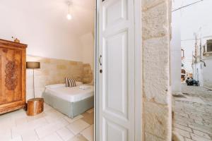a bedroom with a bed next to a door at Dimora Anderì in Polignano a Mare
