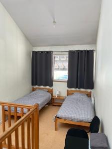 two twin beds in a room with a window at Le Prieure Valette in Hérouville-Saint-Clair