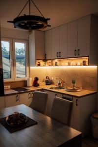 a kitchen with a table and chairs and a sink at Šapat Vetra vikendica in Vršac