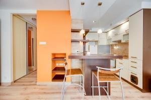 - une cuisine avec un bar et deux chaises dans l'établissement Orange by OneApartments, à Gdańsk 8 autres photos