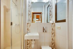 une salle de bain avec lavabo et douche dans l'établissement Orange by OneApartments, à Gdańsk