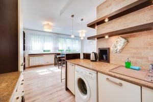 - une cuisine avec lave-linge et sèche-linge dans la chambre dans l'établissement Orange by OneApartments, à Gdańsk