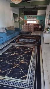 a living room with a blue couch and a marble floor at Mohan Homestay in Kuala Terengganu +2 photos