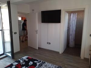 ママイア・ノルドにあるApartament BIAの壁掛けテレビのある部屋に立つ男