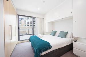 a bedroom with a large bed with a large window at Beachfront Serenity Glenelg in Glenelg