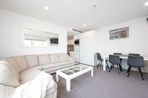 a living room with a white couch and a table at Beachfront Serenity Glenelg in Glenelg +16 photos