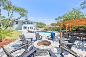 a patio with chairs and a fire pit and a pool at Vilano Rose Slps 24, 6Bds, 5 Bths, Pool, Wlk to Beach, Golf, Pets in Saint Augustine