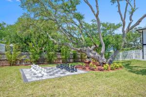 a chess board in a yard with a tree at Vilano Rose Slps 24, 6Bds, 5 Bths, Pool, Wlk to Beach, Golf, Pets in Saint Augustine