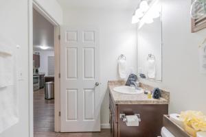 a white bathroom with a sink and a mirror at Lower Northern Tanada Suite 2.0 (B) in North Pole +22 photos