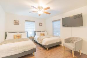 a bedroom with two beds and a chair and a ceiling fan at Lower Northern Tanada Suite 2.0 (B) in North Pole