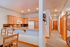 a kitchen with wooden cabinets and a dining room with a table at Bridgepoint Condo 11 in Ketchum