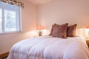 a white bed in a bedroom with a window at Bridgepoint Condo 11 in Ketchum