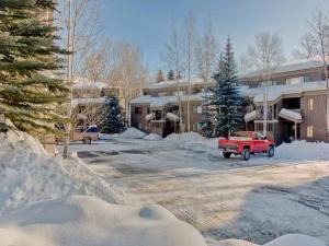 a red truck parked in a snow covered parking lot at Bridgepoint Condo 11 in Ketchum