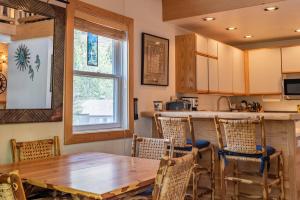 a kitchen and dining room with a wooden table and chairs at Edelweiss Condo 223B in Ketchum