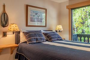 a bedroom with a bed with two lamps and a window at Edelweiss Condo 223B in Ketchum +17 photos