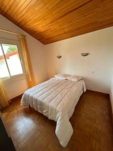 a bedroom with a large bed in a room with a window at La Pampa in Mimizan