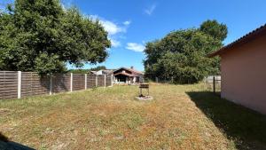 a yard with a fence and a house at La Pampa in Mimizan