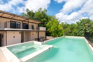 a large swimming pool in front of a house at Departamento amplio con balcon y mini alberca privada in Tulum