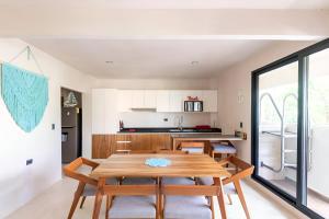 a kitchen and dining room with a wooden table and chairs at Departamento amplio con balcon y mini alberca privada in Tulum