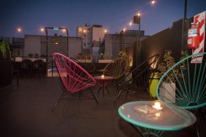 a group of chairs and tables on a balcony at night at PH Palermo Hostel in Buenos Aires