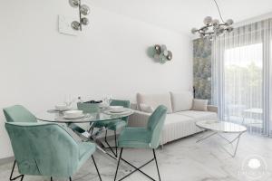 a living room with a white couch and a table and chairs at Baltic Lux Pogorzelica II in Pogorzelica