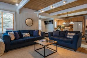 Una sala de estar con un sofá azul y una mesa. en Creekside Condo 1335, en Sun Valley