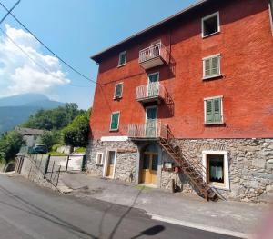 a large red brick building with a fire escape at B&B La Presef in Vezza dʼOglio