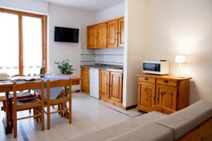a small kitchen with a table and a microwave at Gardenia Casa Vacanze in Alghero