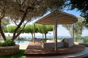 a pavilion with a couch under a canopy next to a pool at TheTree Villa, with Heated Pool & Spa Whirlpool, By ThinkVilla in Gállos