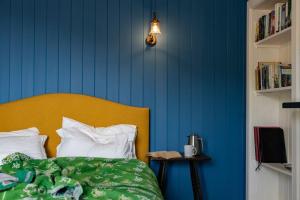 ein Bett mit gelbem Kopfteil und blauer Wand in der Unterkunft South Shore Cottage in Acharacle