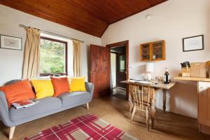 a living room with a couch and a table at Sawmill Cottage in Acharacle