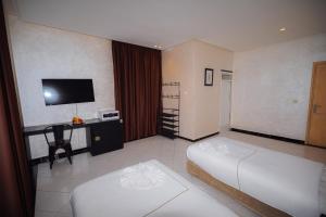 a hotel room with two beds and a television at Hotel Dakhla ville bis in Dakhla