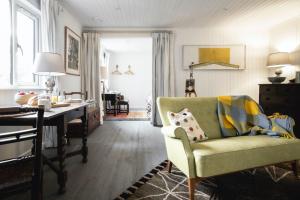 a living room with a green chair and a desk at Timber Cottage in Acharacle