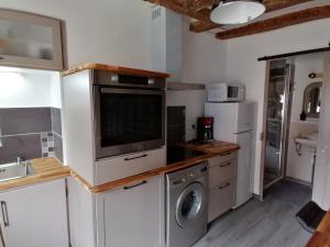 a kitchen with a washing machine and a washer and dryer at Maison ancienne in Azay-le-Ferron