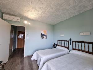 Postel nebo postele na pokoji v ubytování Hôtel AMBEILLE