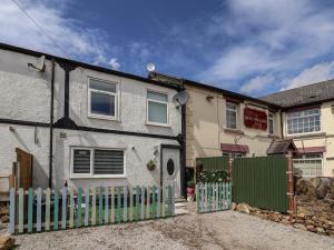 una casa bianca con una recinzione davanti di 2 Stoneleigh Cottage a Wrexham