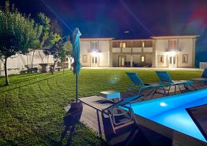 a villa with a swimming pool at night at Casa da Gândara in Ponte de Lima