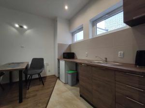 a kitchen with a sink and a desk and a window at Domus in Ustka