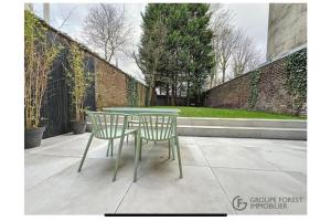 ein grüner Tisch und zwei Stühle auf einer Terrasse in der Unterkunft Luxury house 8pp near subway and Lille center in Marcq-en-Baroeul