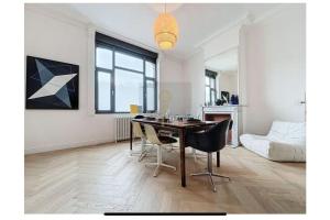 ein Esszimmer mit einem Tisch und Stühlen in einem Raum in der Unterkunft Luxury house 8pp near subway and Lille center in Marcq-en-Baroeul