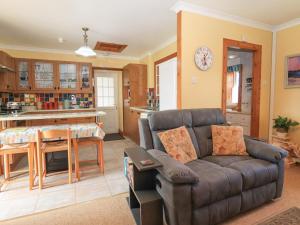 a living room with a couch and a kitchen at Hazel's Cottage in Campbeltown