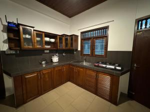 a kitchen with wooden cabinets and a counter top at Win Min Accommodation in Homagama