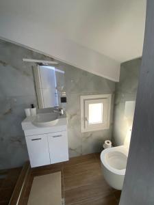 a bathroom with a white sink and a toilet at LUZ DEL SOL Villas in Nea Moudania +28 photos