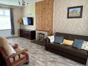 a living room with a couch and a fireplace at Martha's Cottage in Donaghcloney