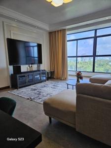 un soggiorno con divano e TV a schermo piatto di lovely 2 bed, 2.5 bath condo a Dar es Salaam