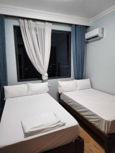 due letti in una stanza con finestra di Lovely 3 Bedrooms 3 5 bath Apart with Pool and gym a Dar es Salaam