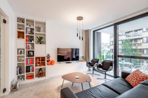 a living room with a couch and a tv at Luxury apartment in the centre of Ostend with terrace in Ostend