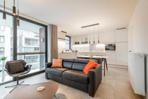 a living room with a couch and a kitchen at Luxury apartment in the centre of Ostend with terrace in Ostend