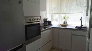a kitchen with a stove and a sink and a window at Holiday home in Balatonmariafürdo 19358 in Balatonmáriafürdő
